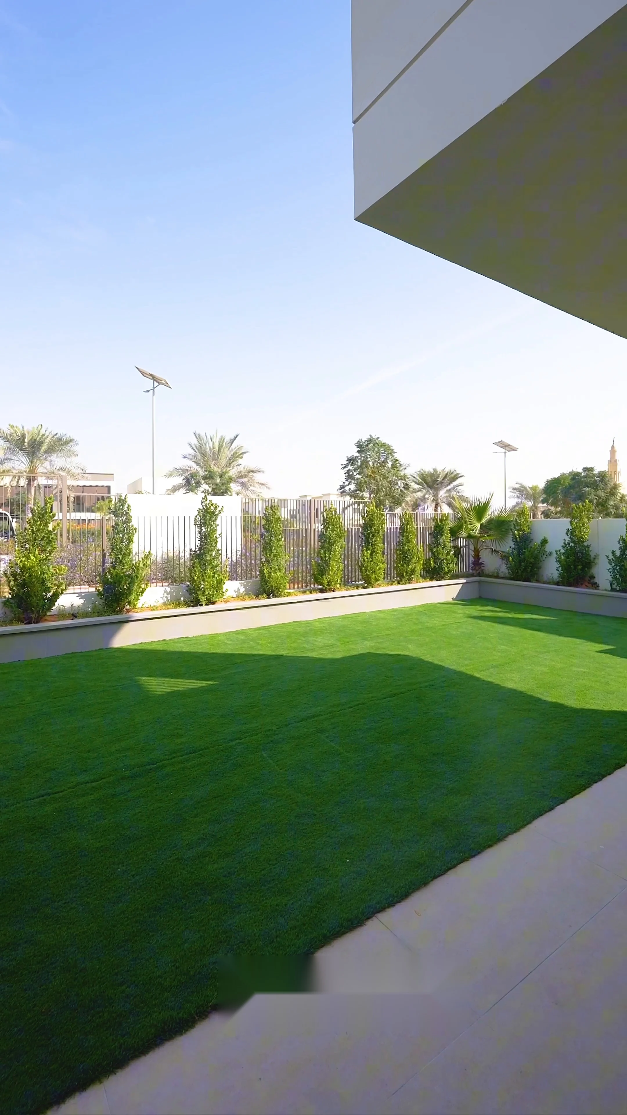 Landscaped rear garden with artificial lawn, planted borders and a screened boundary