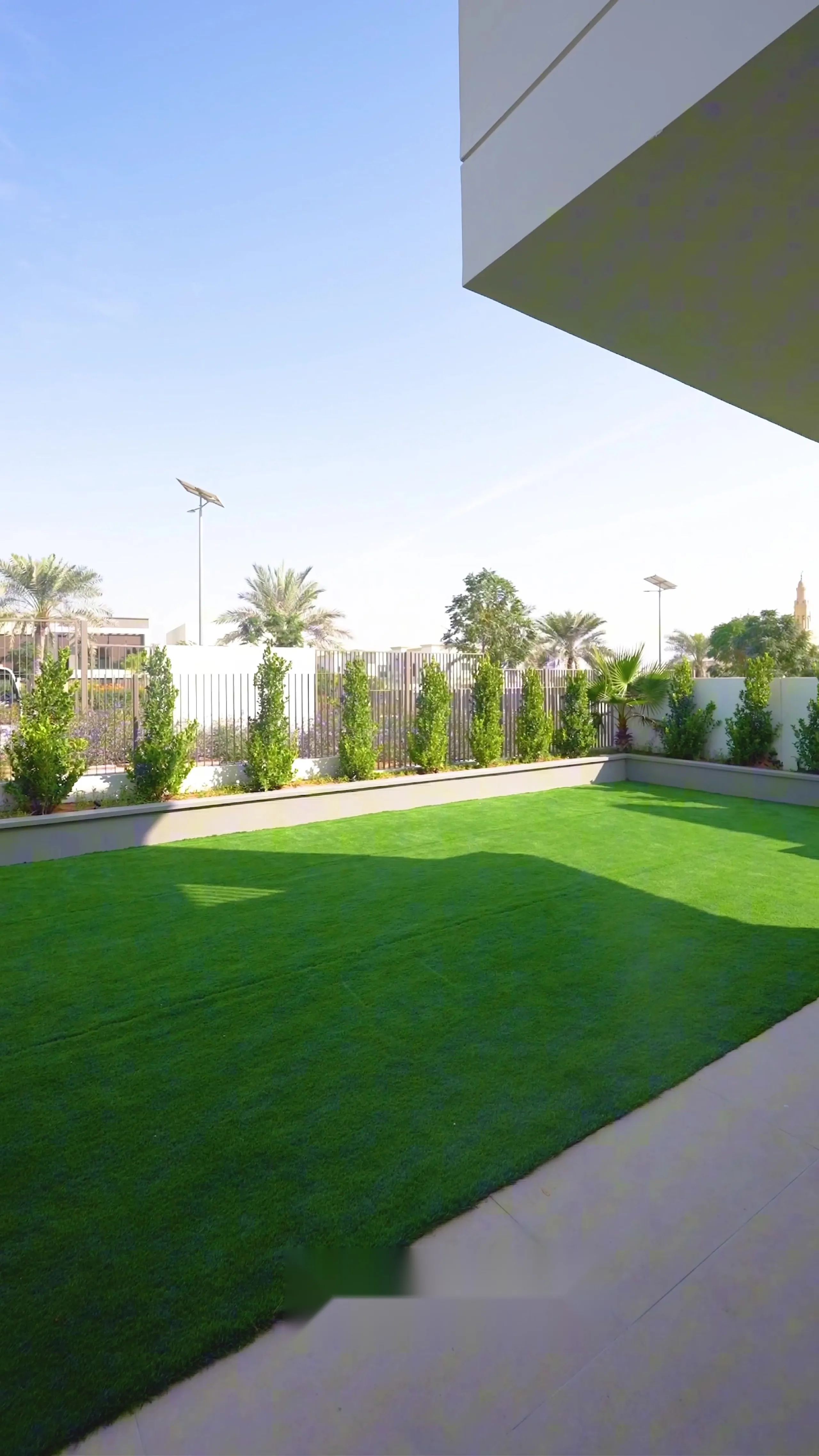 Landscaped rear garden with artificial lawn, planted borders and a screened boundary