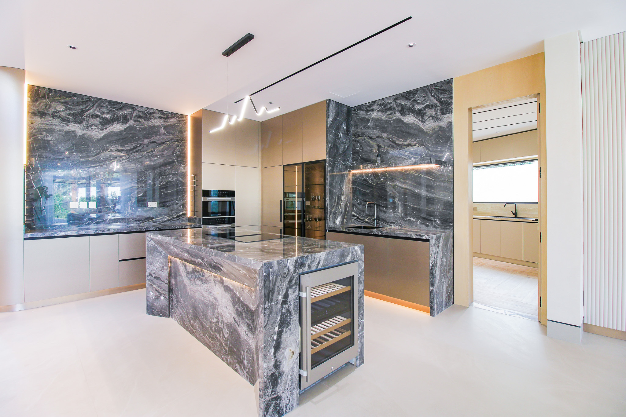 Bespoke kitchen joinery in warm timber and dark marble, Jumeirah Golf Estates villa